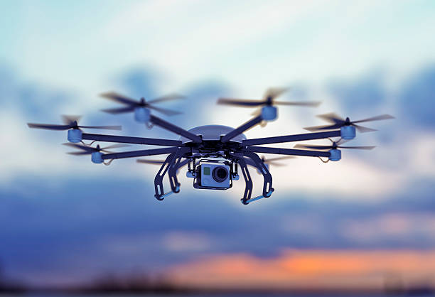 a drone flying in a cloudy sky where the sun goes down